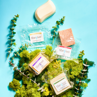 A grouping of Tiber River bar soaps, shampoo and massage bar in biodegradable Nature Flex packaging